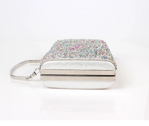 Detail of silver evening clutch featuring colorful rhinestones and metallic chain handle