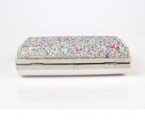 Macro detail of silver clutch bag with colorful rhinestones and metal frame structure