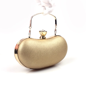 Detail of gold pod-shaped evening clutch with crystal clasp and metallic texture