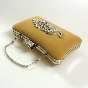 Detailed side view of velvet evening clutch with sparkling rhinestone peacock decoration
