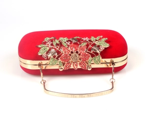 Detail of red velvet evening bag with colorful floral rhinestones and gold handle