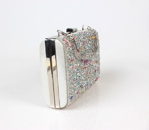 Detail of evening clutch with colorful sequins, rhinestones and silver metal handle