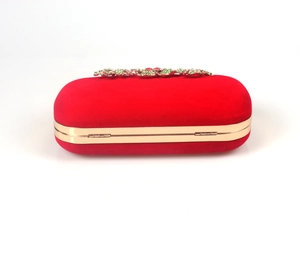 Detailed close-up of a red velvet evening bag featuring floral crystal rhinestones