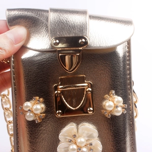 Detail der champagner-goldenen Mini-Tasche mit Perlenblumen und funkelndem Strass-Besatz