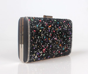 Detail of black evening clutch bag with colorful rhinestones and silver metal frame