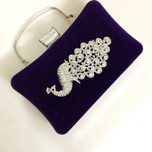 Macro detail of purple velvet clutch with exquisite peacock crystal embellishments