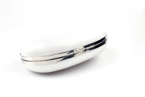 Detail of silver evening clutch bag featuring a pearlescent textured surface and metal clasp