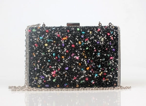 Detailed view of black clutch with colorful rhinestones and silver chain strap