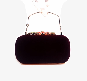 Detail of burgundy velvet evening bag with ornate golden leaf and gemstone clasp
