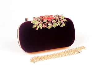 Detailed close-up of velvet evening clutch with luxury crystal floral leaf decoration