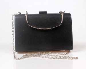 Close-up of black evening clutch bag with silver metal handle and chain strap detail