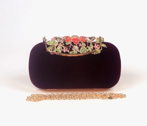 Detail of velvet evening bag with gold floral clasp and colorful crystal embellishments