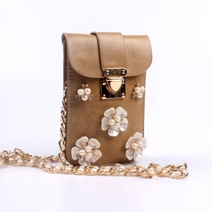 Detail von Blumenverzierung mit Perlen und Diamanten auf brauner Leder-Handytasche