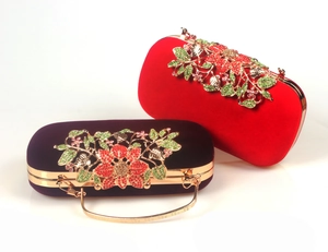 Detailed close-up of velvet evening clutches with ornate golden floral crystal inlay