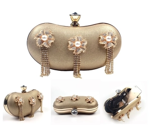 Detail view of gold floral evening clutch with rhinestone tassels and internal phone storage