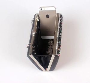 Detail view of rhinestone evening bag interior with silver chain and phone for scale