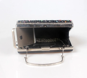 Detail view of black evening clutch bag with colorful rhinestones and silver chain strap