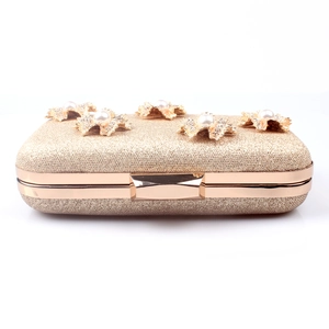 Elegant gold evening clutch with glitter texture and pearl-studded metal flower clasp