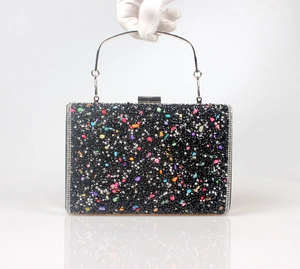 Close-up of luxury evening clutch with colorful stones and black crystal inlay