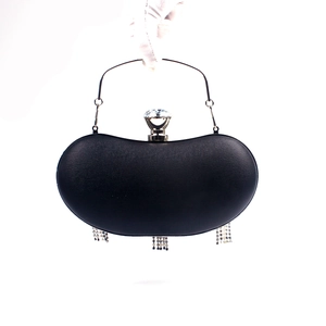 Detail of black evening clutch with crystal lock, metal handle, and long bead tassels