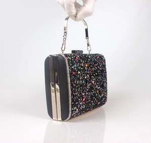 Detail view of colorful rhinestone evening clutch bag with circular metal handle