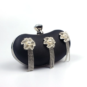 Close-up of black satin evening bag with silver rhinestone flower tassels and crystal clasp