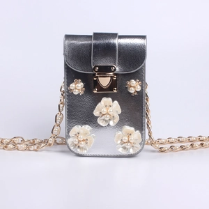 Detail der silbernen Mini-Blumentasche mit Perlenkette und funkelnden Strass-Blüten