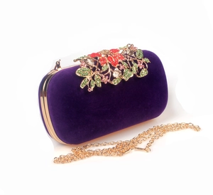 Detail of velvet evening clutch with golden leaf metalwork and colorful rhinestones
