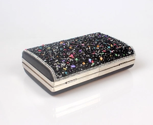 Macro view of black evening clutch bag with sparkling rhinestones and colorful stones