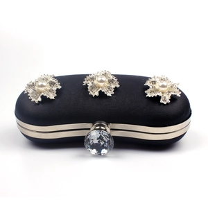 Detail of black evening clutch with floral pearl accents and crystal ball clasp