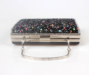 Detailed close-up of a black evening clutch bag with colorful crystals and silver handle