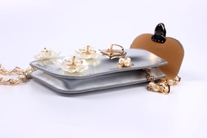 Detail der silbernen Umhängetasche mit Perlen-Blumen und goldener Metallkette