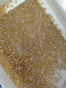 Detailed view of faceted champagne crystal beads with shimmering rainbow AB coating