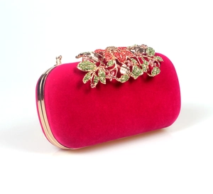 Detail view of rose red velvet evening clutch with crystal leaf metal clasp