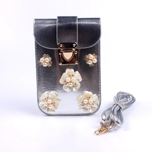 Detail der silbernen Handy-Tasche mit 3D-Blumen, Perlenmitte und goldenem Verschluss