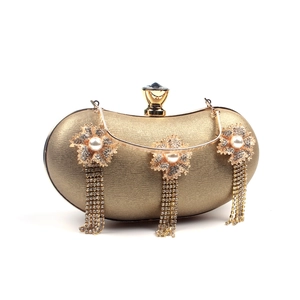 Detail of gold evening clutch with pearl flower accents and sparkling rhinestone tassels