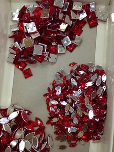 Detailed macro view of red crystal rhinestones with silver metal sewing base for evening bags