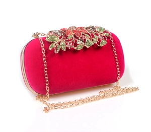 Detailed close-up of velvet evening bag with ornate diamond-encrusted leaf clasp