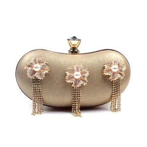 Detail of gold evening clutch featuring pearl flowers and long rhinestone tassels