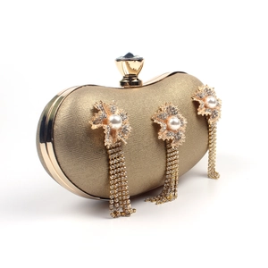 Detail of gold evening clutch featuring pearl flowers and sparkling rhinestone tassels