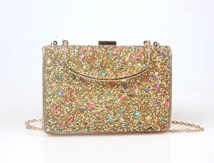 Detail of gold crystal evening clutch with colorful gemstones and U-shaped metal handle
