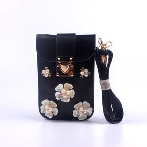 Detail der schwarzen Handytasche mit Perlenblumen und goldenem Herzverschluss
