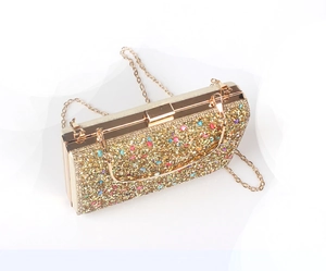Detail of gold evening clutch with colorful rhinestones and elegant metal chain strap