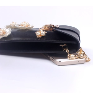Detailansicht der schwarzen Perlentasche mit Goldkette und Smartphone zum Größenvergleich