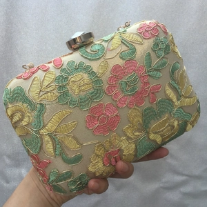 Detailed embroidery on floral evening clutch with crystal clasp and gold silk fabric