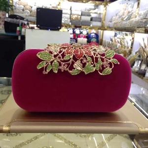 Detail of fuchsia velvet clutch featuring a crystal flower clasp with colorful rhinestones