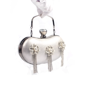 Detail of silver floral evening bag featuring pearl accents and long rhinestone tassels