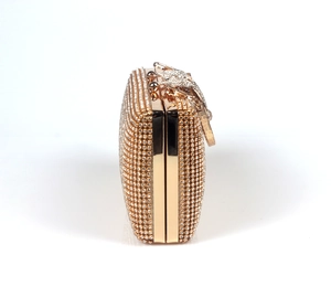 Dettaglio della pochette dorata con strass scintillanti e chiusura a forma di fiocco