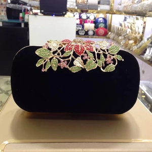Close-up of luxury velvet evening clutch with floral crystal clasp and colorful rhinestones