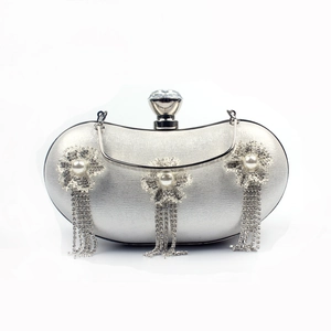 Detail of silver evening clutch featuring pearl crystal flowers and rhinestone fringe